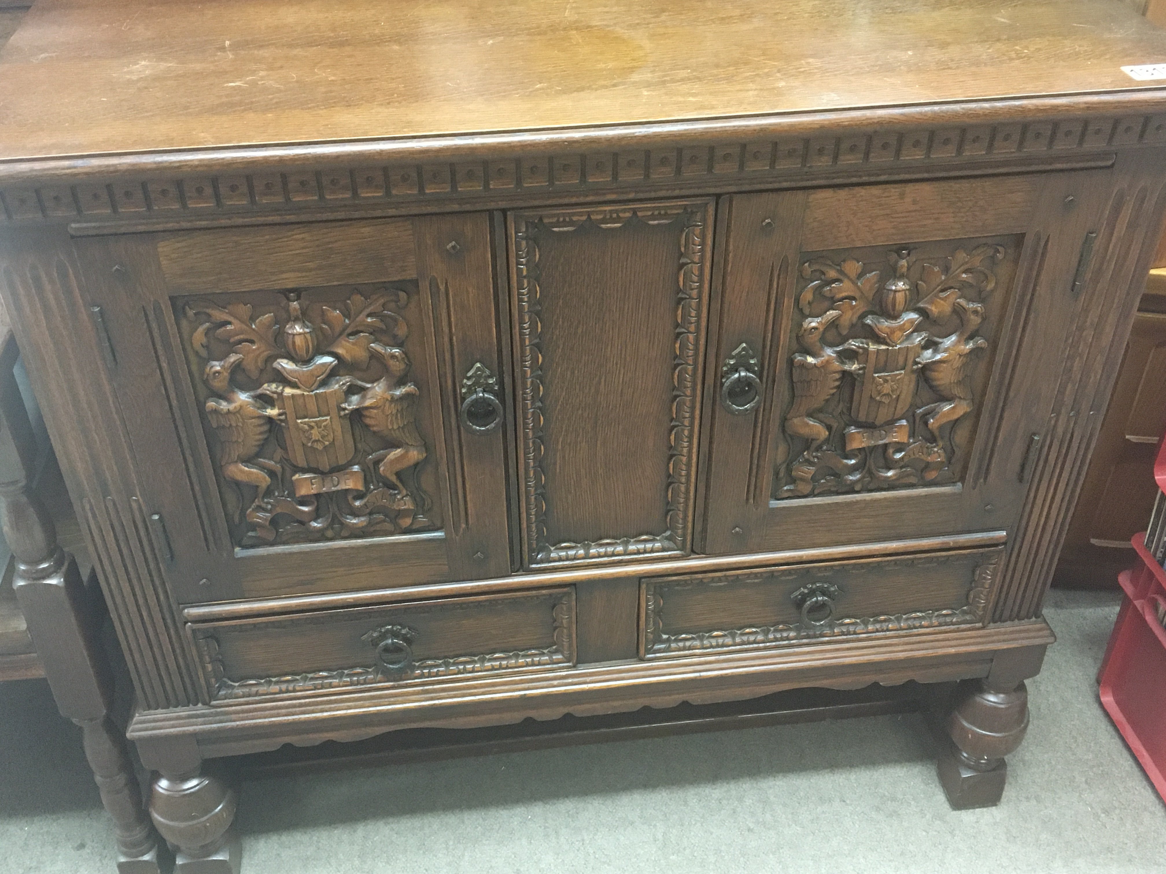 A small carved oak cabinet the cupboard doors with