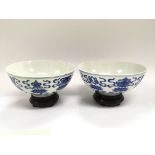 A pair of Chinese blue and white bowls raised on h