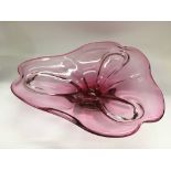 A large pink art glass dish, approx diameter 38cm.