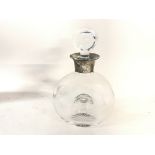 A glass decanter with a Hallmarked silver collar.
