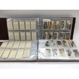 A collection of cigarette card sets in two albums.