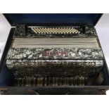 A cased Alvari accordion.