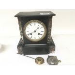 A Victorian black slate and marble mantel clock the French movement striking on a bell.