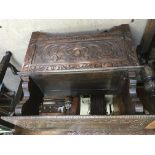 A oak carved monks bench The lift up seat above a