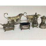 Two silver sauce boats with scroll handles and a s