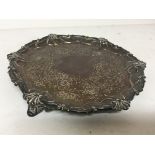 A Victorian silver tray with a shaped edge and scr