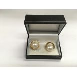 A pair of 18ct gold pearl earrings set with diamon