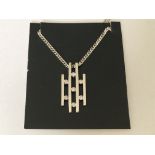 A modern style diamond set pendant and chain in wh