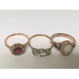 Three Vintage gold rings (carat marks worn) set with a red stone and seed pearl a cameo and white