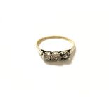 An 18ct gold three stone ring. Size P and 1.7g.