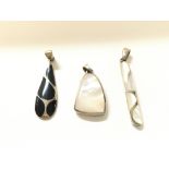 Three silver modern design pendants.