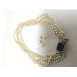A simulated quadruple pearl necklace with a large simulated sapphire and diamonds with matching