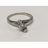 A 18 ct white gold ring inset with three diamonds size N .