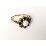 An Opal and sapphire cluster ring in yellow gold