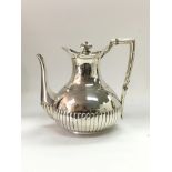 A silver teapot, London 1881 by W&J Barnard with half gadrooned decoration. Approx 726g.