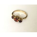 A 3 stone crossover garnet set ring in 9ct gold