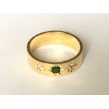 An emerald and diamond set ring in 18ct gold