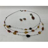 A 3 string amber choker necklace together with a pair of silver studs and a silver and amber