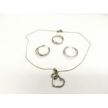 A suite of diamond set in silver jewellery comprising a heart shaped pendant, a pair of earrings and