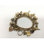A gold charm bracelet set with 9ct and 15ct charms