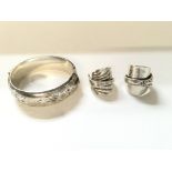 Two modern design silver rings and bracelet.