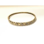 A 9ct gold bangle with diamonds. Weight 8.7g