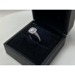 A 14ct white gold halo design ring set with an approx 0.90ct diamond and surrounded by approx 40