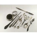 A small collection of silver items comprising a pen, two button hooks, spoons etc.