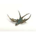 A silver and turquoise brooch in the form of a swa