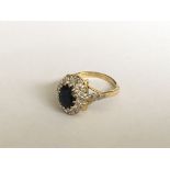 An 18ct gold oval sapphire and diamond cluster rin