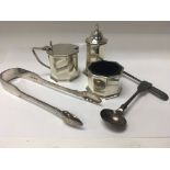 A silver cruet set with two spoons and sugar tongs