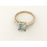 A square shaped blue topaz with diamond set should