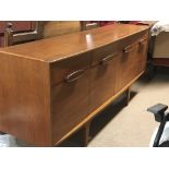 A Mid 20th century Teak sideboard the rectangular top above four drawers and cupboards.