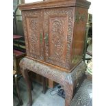 A oak oak cabinet The pair of carved doors enclosi