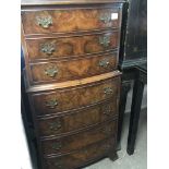 A small walnut bow fronted chest with flight of se