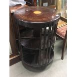 An inlaid mahogany circular shaped revolving bookc