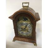 A walnut cased mantel clock with arch moon roller