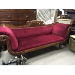 A Regency mahogany sofa with a shaped top rail and scroll ends on fluted legs.