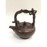 A Chinese terracotta teapot, the handle decorated