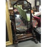 A Victorian mahogany cheval mirror with a shaped p