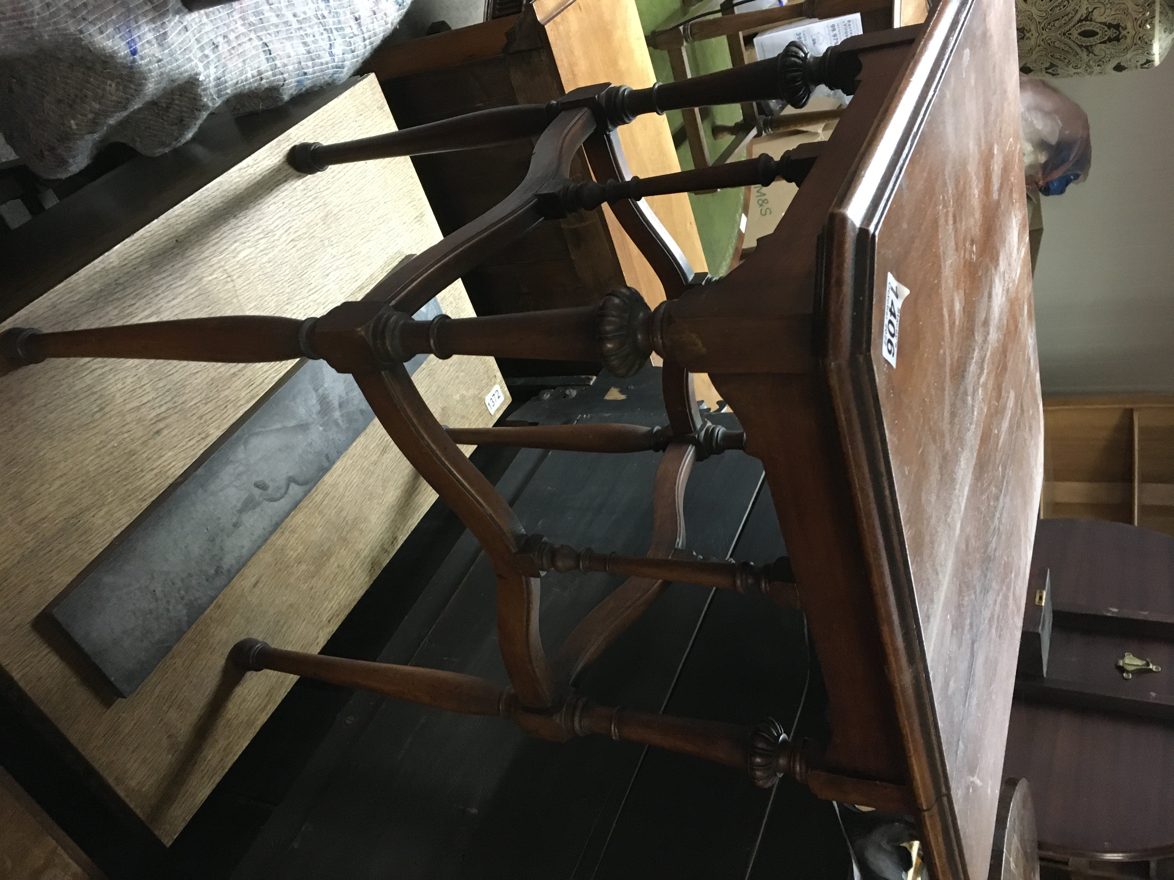 A Edwardian mahogany table on turned legs .