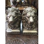 Two pairs of bookends in the form lion heads .