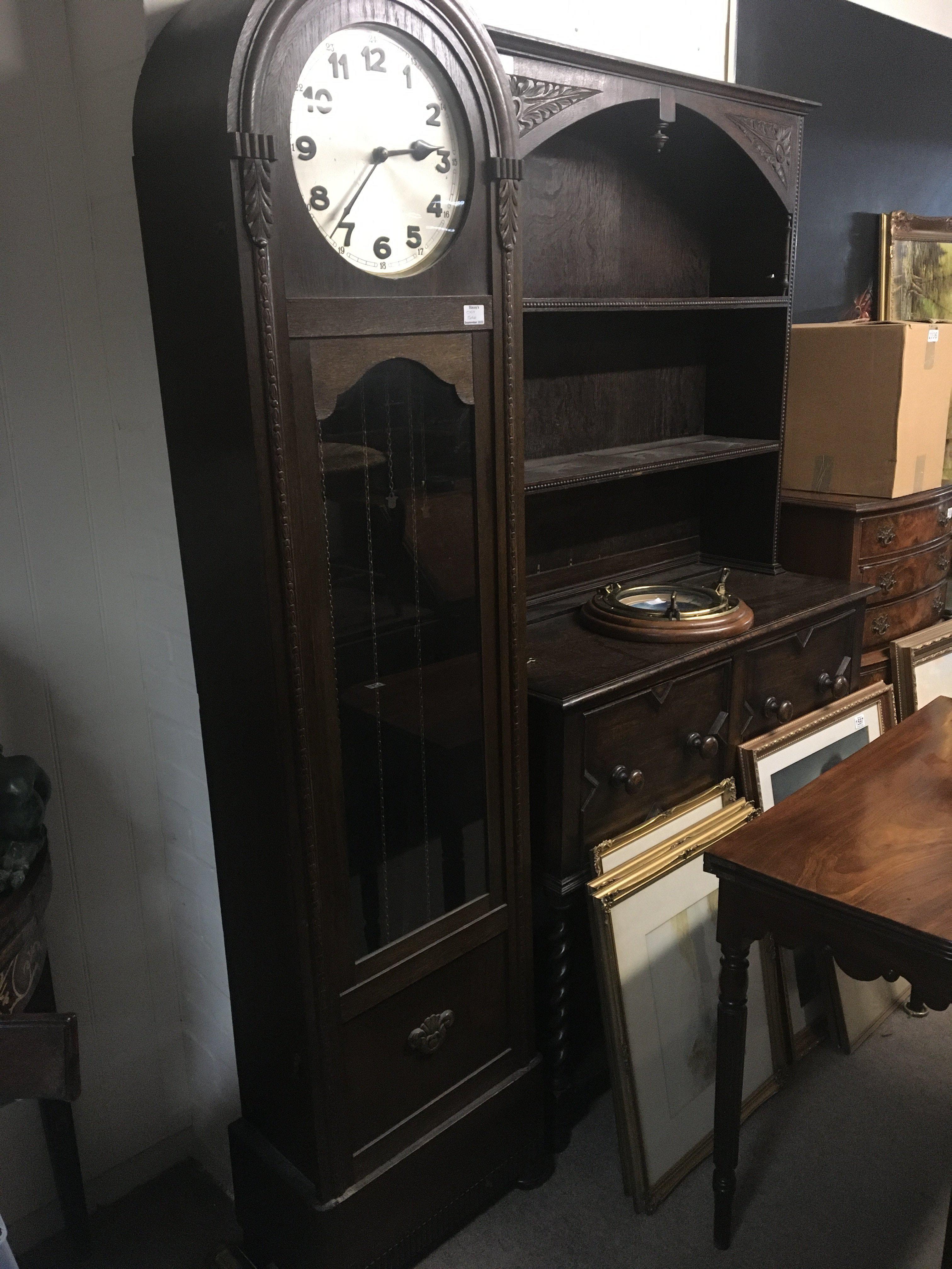 An oak long case clock with visible weights and pendulum. three train movement. With three weights