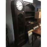 An oak long case clock with visible weights and pendulum. three train movement. With three weights