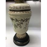 A Victorian oil lamp decorated with flowers and fo