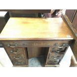 A mahogany kneehole desk fitted with nine drawers