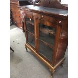 A walnut bookcase with a raised shaped pediment ab
