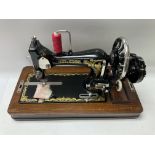 A cased Frister & Rossman manual sewing machine.