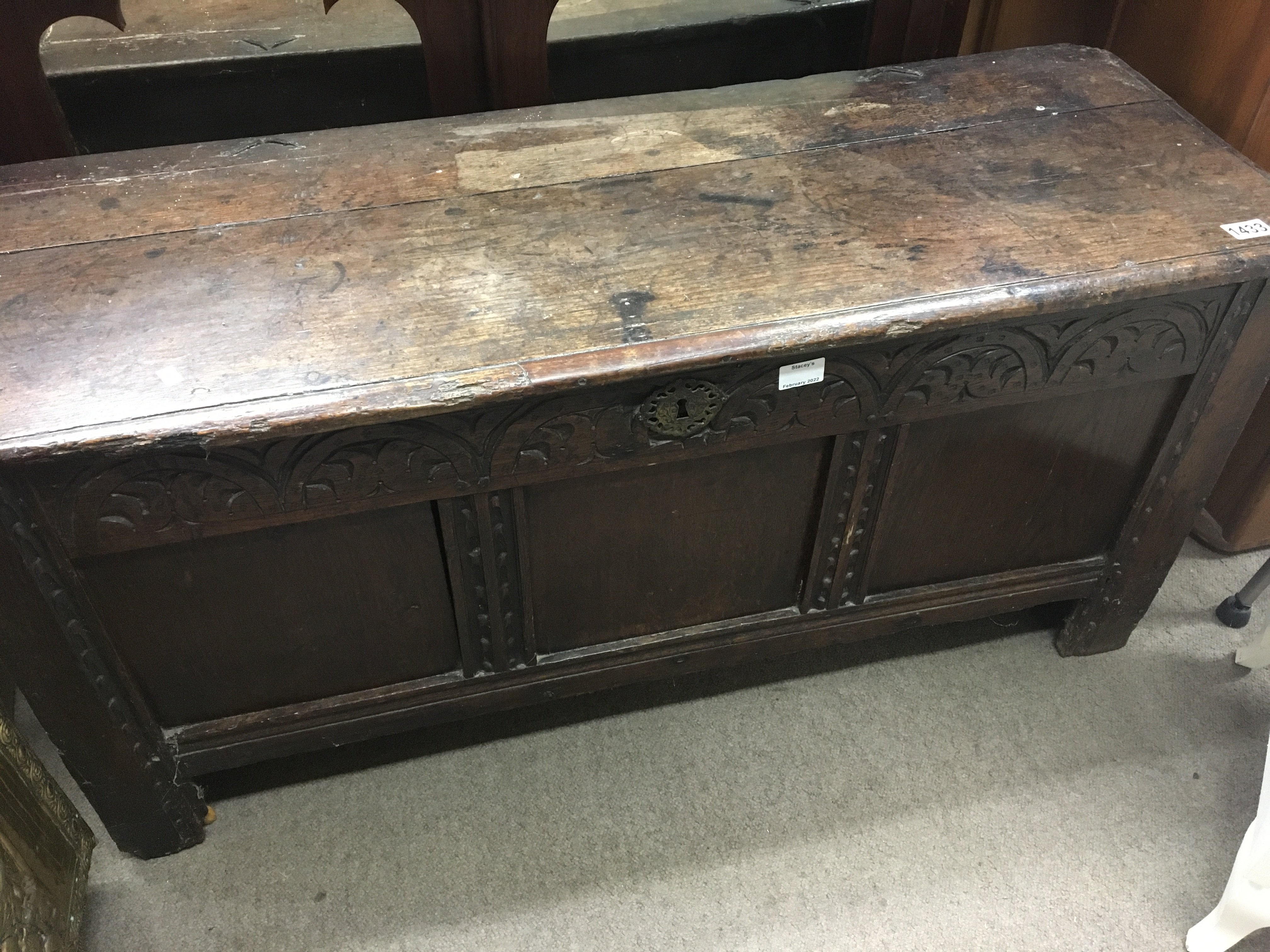 An 18th century carved oak coffer with a rectangular top above a panel front.