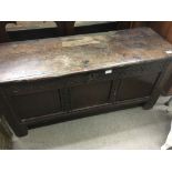 An 18th century carved oak coffer with a rectangular top above a panel front.